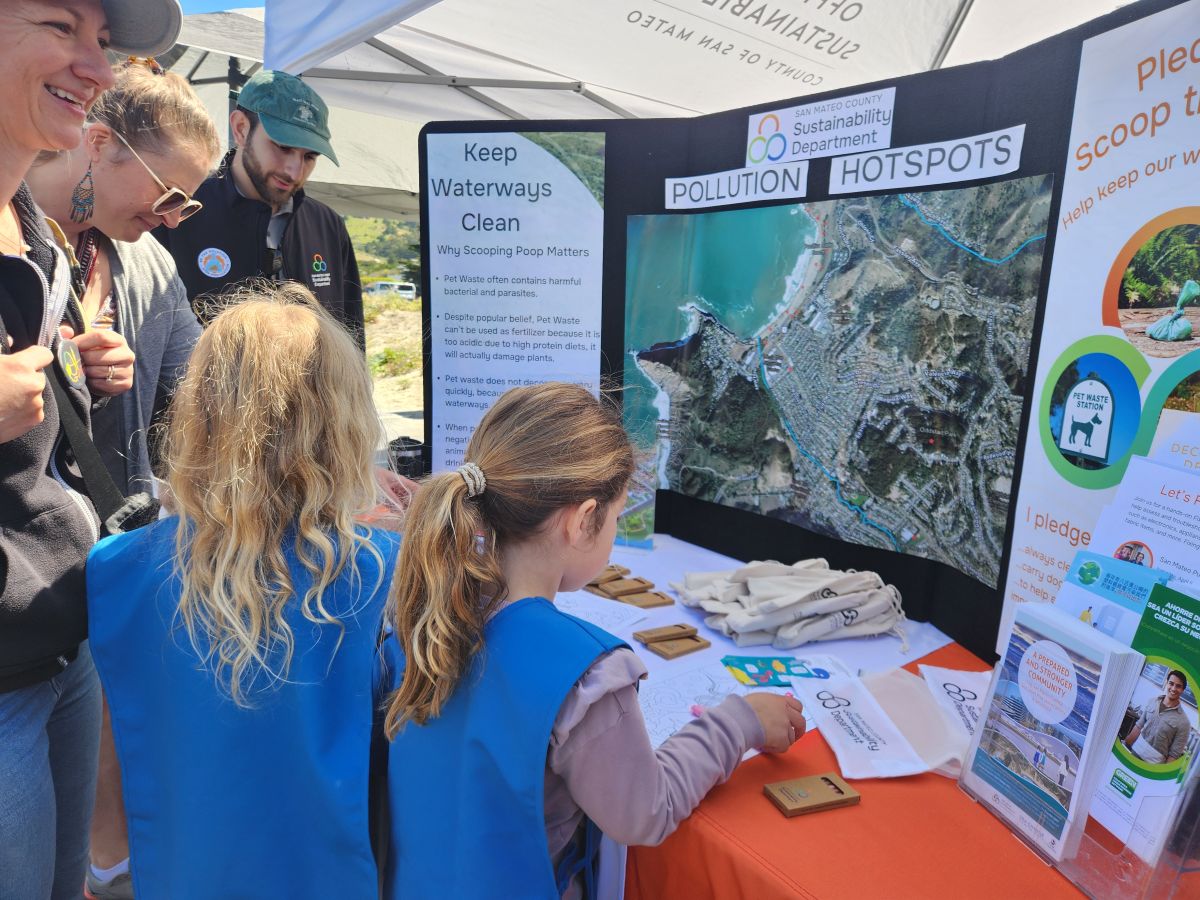 Two children at a booth learning about water pollution.