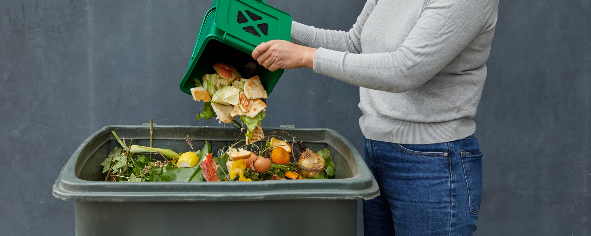 woman adding food waste to compost bin