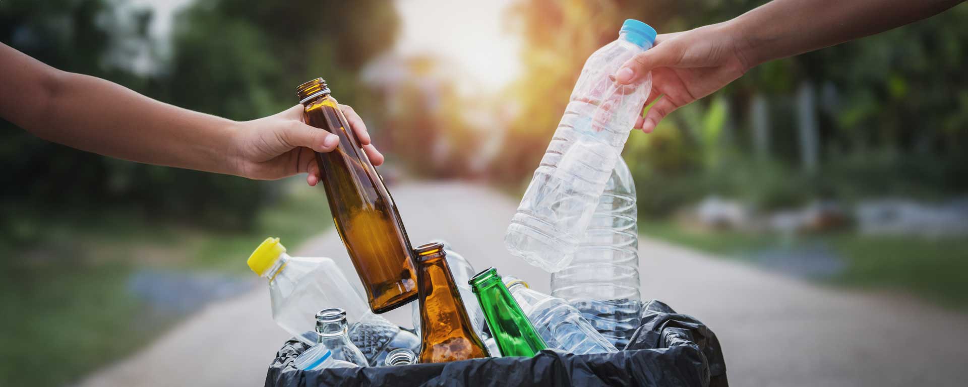 people place plastic and glass bottles into bag, preparing them for CRV redemption